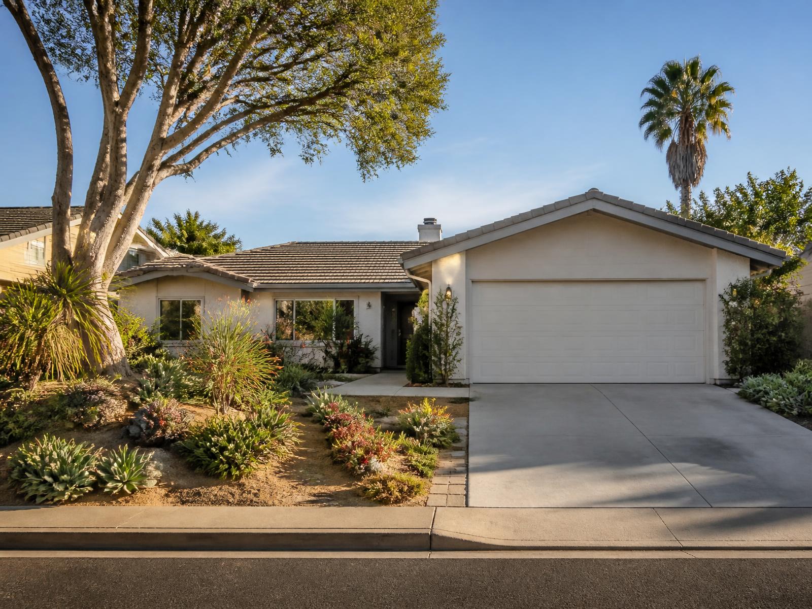 A single-story Southern California home with a tile roof and drought-tolerant front garden